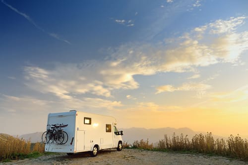 an RV membership programs RV parked on a cliff overlooking a beautiful landscape